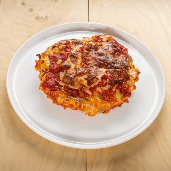 A serving of Jerusalem Cafe's kosher lasagna, topped with melted cheese and rich tomato sauce.