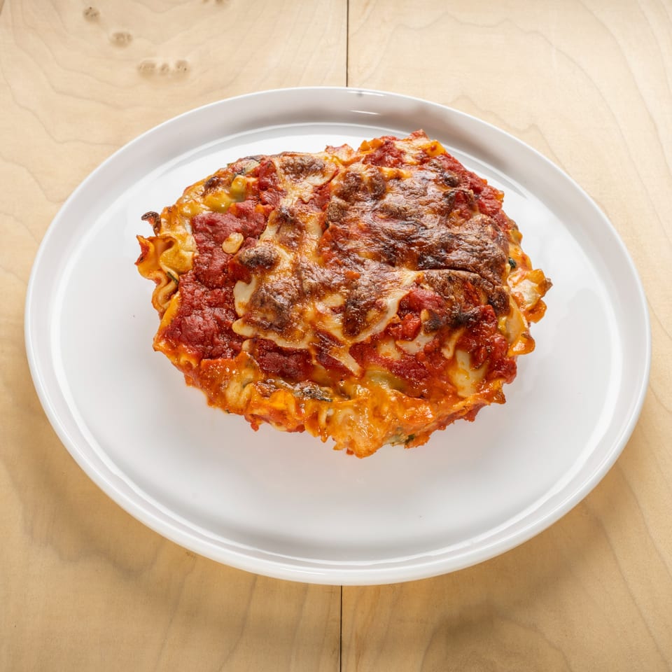 A serving of Jerusalem Cafe's kosher lasagna, topped with melted cheese and rich tomato sauce.