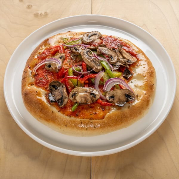 A Jerusalem Cafe kosher pizza with mushrooms, red and green peppers, and red onions on a white plate.